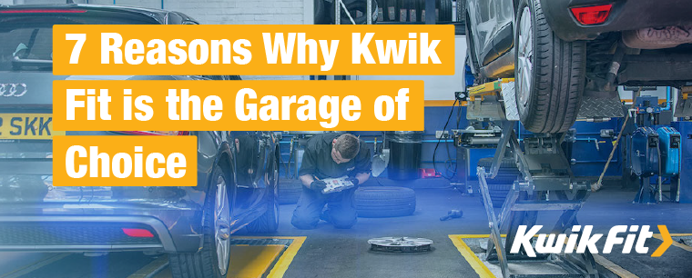 Kwik Fit technician inspecting an Audi in a Kwik Fit garage with another car on a ramp.