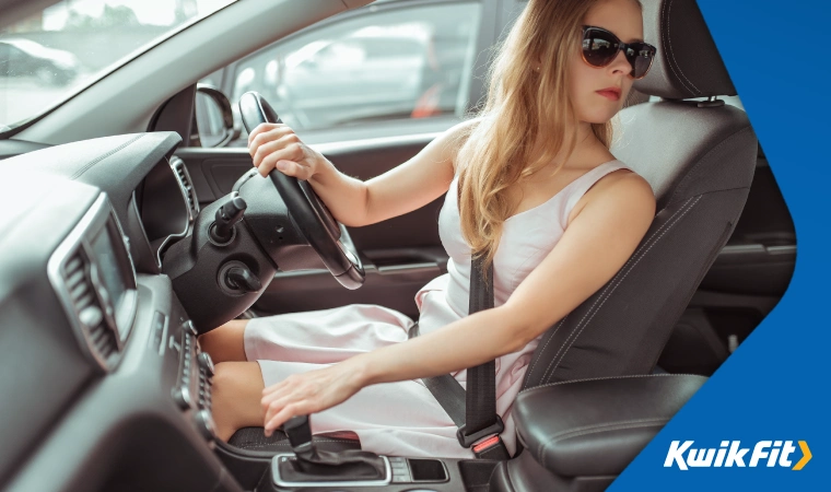 A woman looks over her shoulder as she reverses her car.