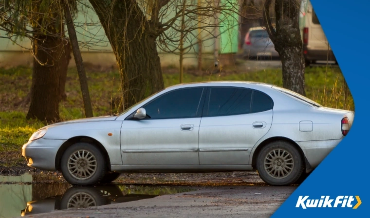 SORN car sits on a large driveway, looking run down.