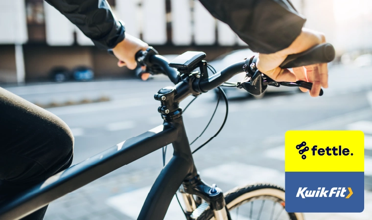 A close-up of someone holding the handlebars of an electric bicycle.