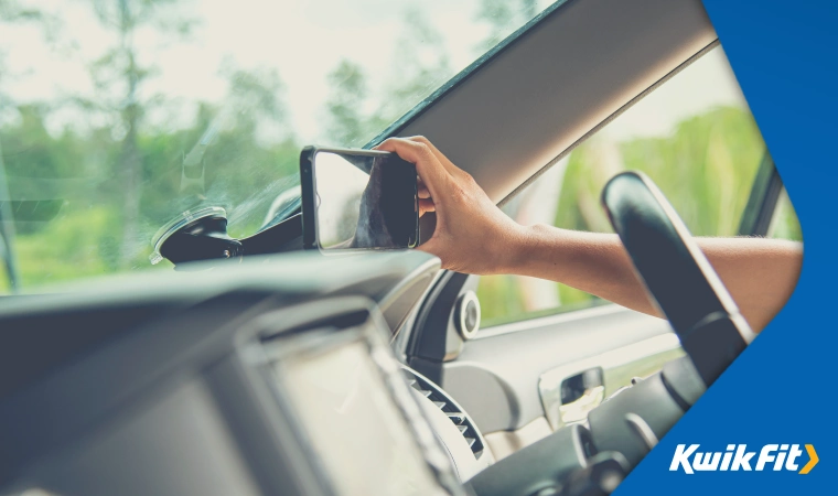 Person adjusting car phone holder on the dashboard.