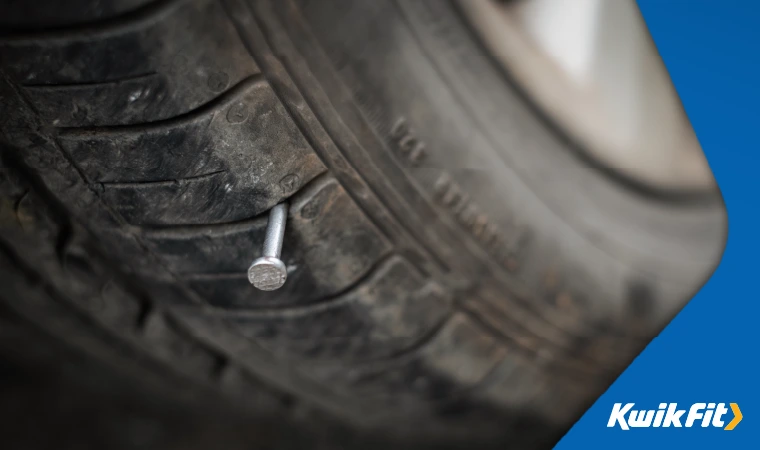 A nail sticking out of a car tyre.