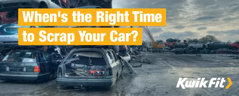 Cars piled on top of each other in a scrap yard.